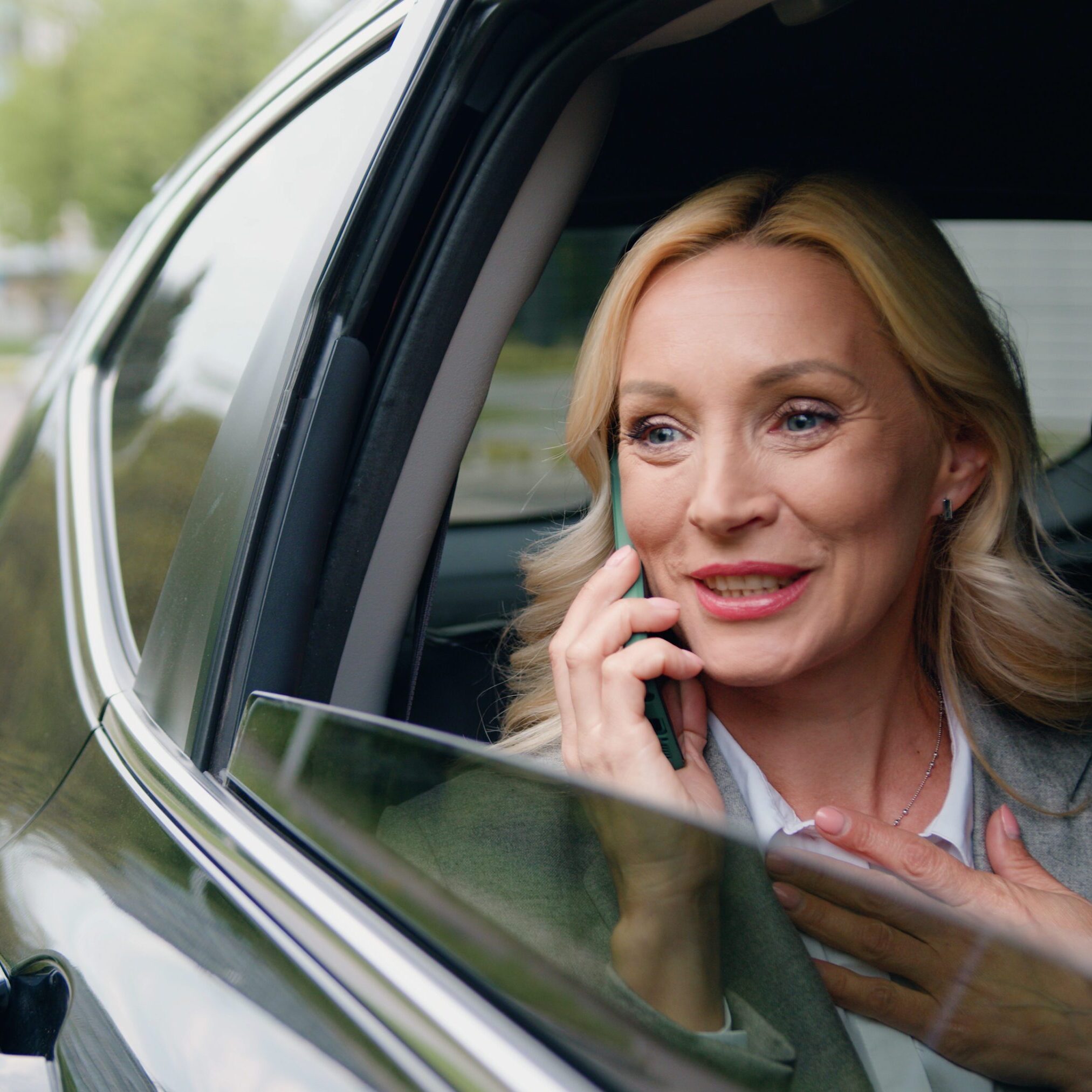 Woman talking on phone in car.